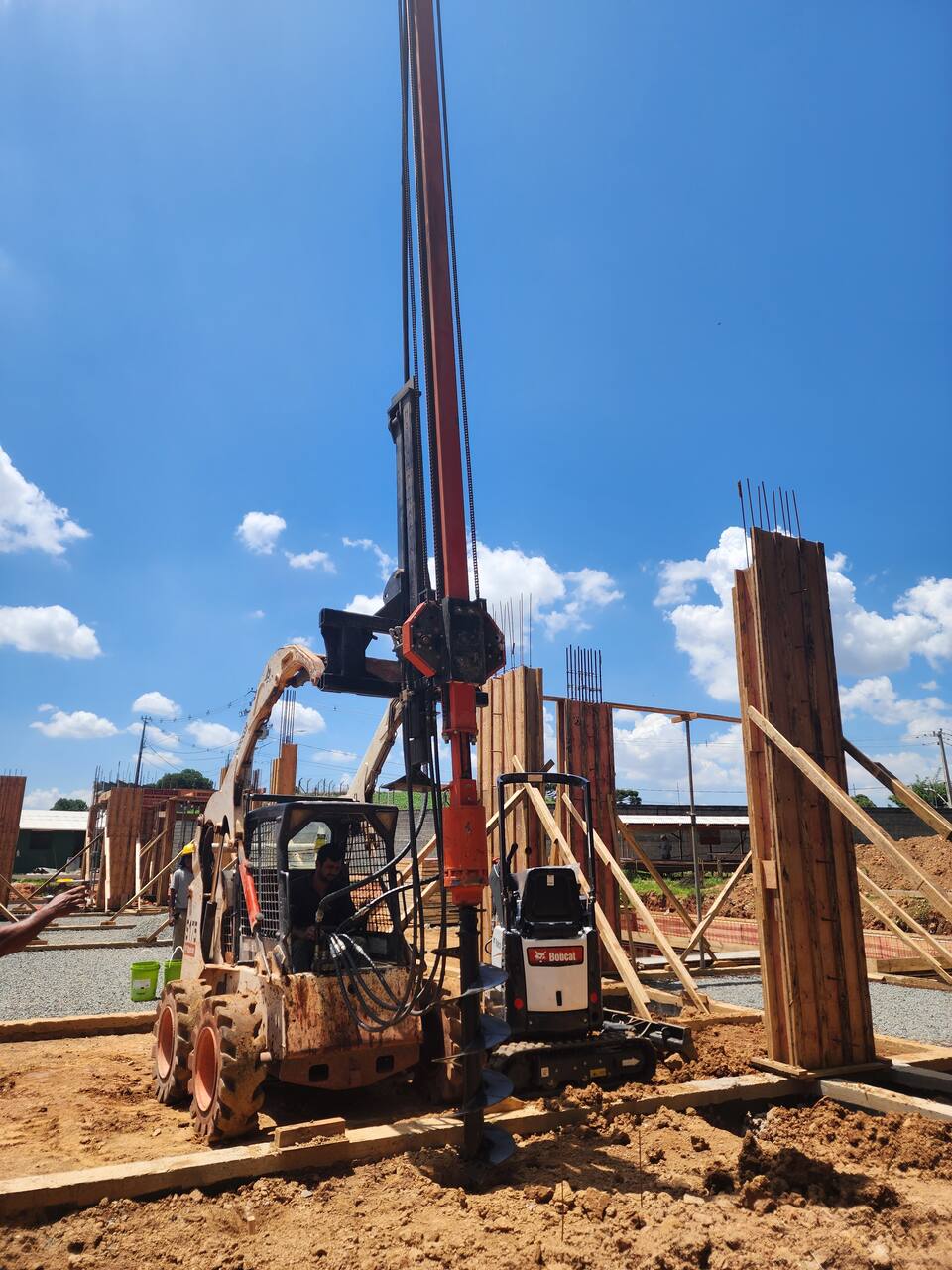 Bobcat perfurando estacas em obra
